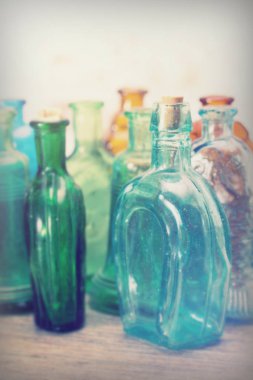 Rustik bir arka plan üzerinde renkli cam şişe