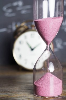 Bir kara tahta arka plan ile ahşap üzerine kum saati