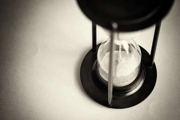 Große schwarze Sanduhr vor blauem Hintergrund — Stockfoto