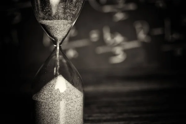 Bir kara tahta arka plan ile ahşap üzerine kum saati — Stok fotoğraf