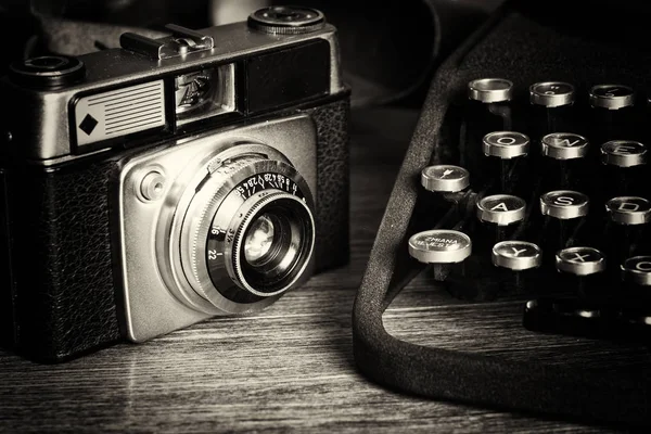 Old vintage retro camera with old-fashioned typewriter — Stock Photo, Image