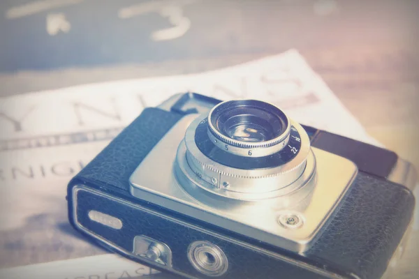 Velha câmera retro vintage com jornal ridicularizado — Fotografia de Stock