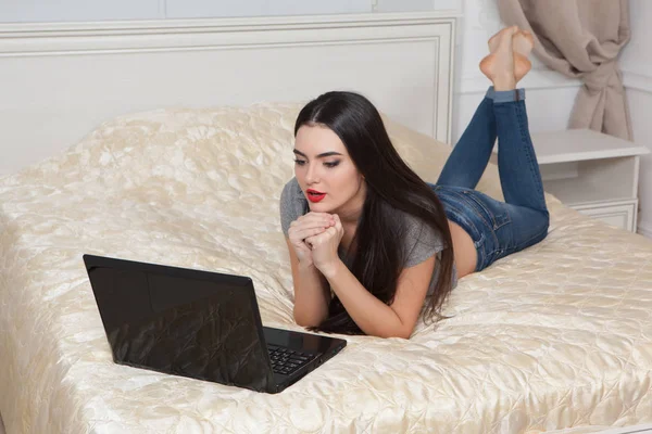 Menina com um computador em casa . — Fotografia de Stock