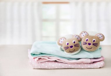 Bir tablo üzerinde çocuk elbise yığını