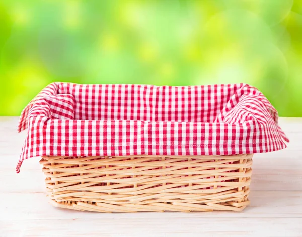 Una Cesta Con Una Jaula Roja Sobre Mantel Sobre Una — Foto de Stock