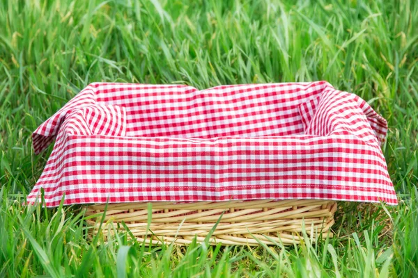 Cesta Con Una Jaula Roja Sobre Mantel Sobre Hierba — Foto de Stock