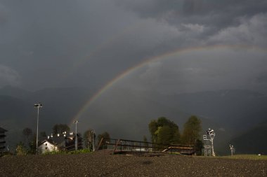Dağlar, ağaçlar ve evlerin arka planda Çift gökkuşağı