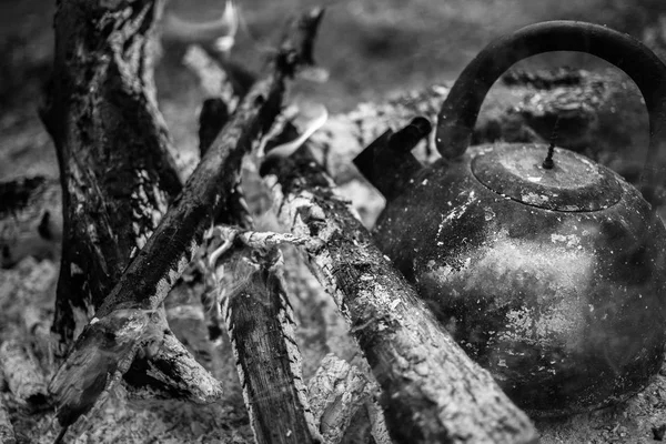 Eski, kaynamış çaydanlık şenlik ateşinde duruyor.. 