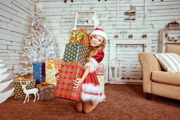 Vzrušený šťastná žena nosí červený kostým santa claus klobouk šokovaní tím, mnoho dárků — Stock fotografie