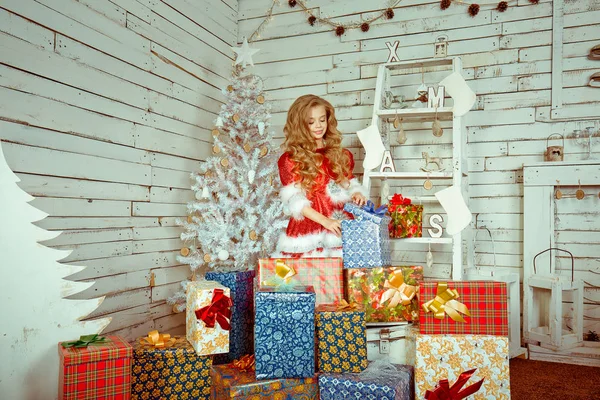 幸せな女の子のギフト ボックスの分離部屋クリスマスが飾られています。冬の休日の概念 — ストック写真