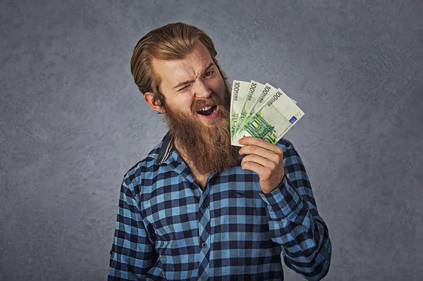 Щасливий чоловік блимає в очі екстатично святкує успіх, тримаючи в руках євро рахунки — стокове фото