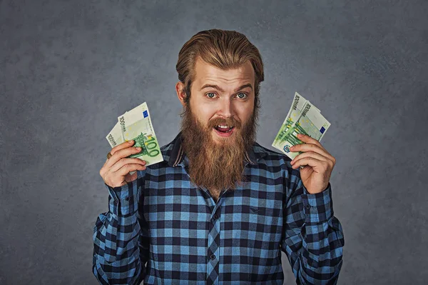 Портрет щасливого молодого чоловіка з грошовими банкнотами євро екстатичний відзначає успіх, що кричить ізольовано на сірому фоні. Концепція досягнення фінансової свободи — стокове фото