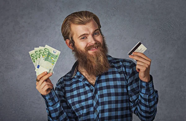 Молодий чоловік купує холдинг, показуючи рахунки за кредитною карткою та грошовими доларами — стокове фото