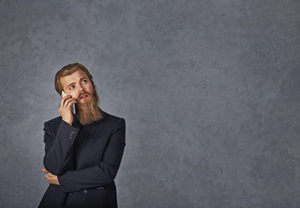 Hombre de negocios hablando por teléfono pensando fondo gris aislado — Foto de Stock