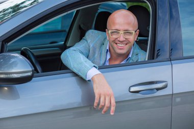 Yeni arabasında gülümseyen yakışıklı adam