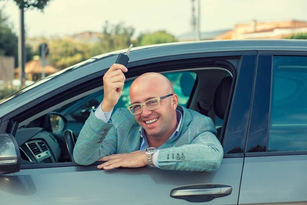 Hombre de negocios guapo mostrando las llaves de su coche nuevo. Retro tonificado p — Foto de Stock