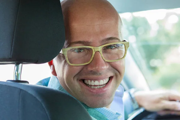 Retrato jovem bonito feliz em mãos de carro novo na roda, tur — Fotografia de Stock