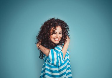 Closeup portrait confident smiling woman holding hugging herself isolated blue wall