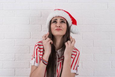 mucize için dua isteyen kadın kırmızı santa claus şapka geçiş parmak kapanış gözleri