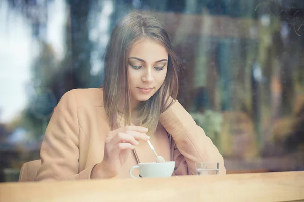 Портрет крупным планом Женщина с удовольствием держит чашку теплого чая кофе, горячий напиток в кофейне — стоковое фото