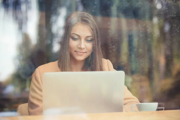 Mujer encantadora mirando en el ordenador portátil durante el descanso en la cafetería, feliz — Foto de Stock