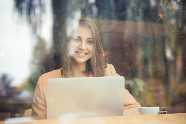 Щаслива бізнес-леді студентка посміхається дивитися на вас з комп'ютером в кав'ярні — стокове фото