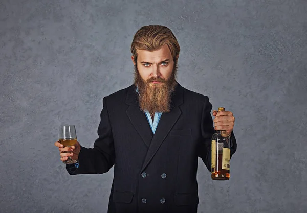 Sakallı adam cam ve şişe viski. İş mavi gömlek ve siyah takım elbise.