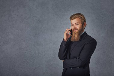 Telefonu izole manifatura gri gri arka plan seyir tutan sakallı iş adamı