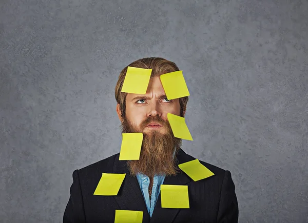 Stock image Overwhelmed bearded business man full of stickers looking up trying to remember his plans