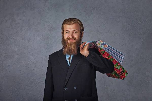 Homem barbudo excitado segurando sacos de compras isolado parede de fundo cinza . — Fotografia de Stock