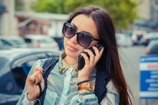 Жінка розмовляє по телефону. Міське відображення на сонцезахисних окулярах — стокове фото