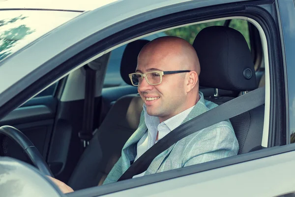 Joven guapo conduciendo su coche y sonriendo — Foto de Stock