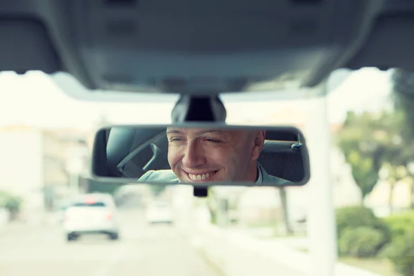 Feliz con mi elección de coche. Retrato joven conductor reflejo en el espejo retrovisor del coche . — Foto de Stock