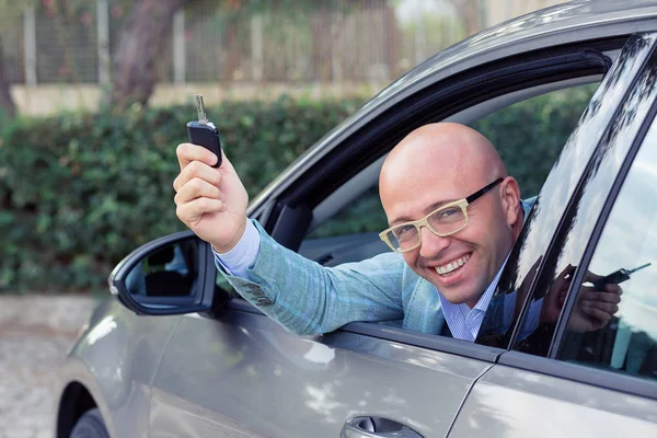 Joven hombre de negocios guapo mostrando las llaves de su nuevo coche . — Foto de Stock