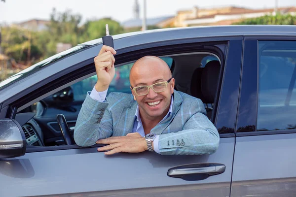 Молодий красивий бізнесмен показує ключі своєї нової машини . — стокове фото