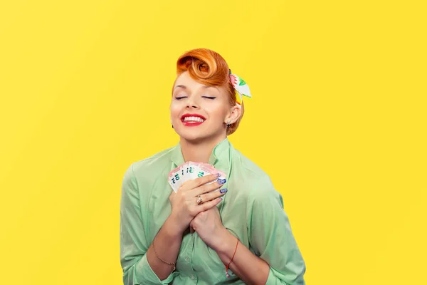 Женщина, обнимающая счета за евро. красивая улыбающаяся счастливая деловая женщина, обнимающая евро банкноты наличными в руках глаза закрыты изолированные желтый фон стены Финансовые сбережения Концепция продажи финансов — стоковое фото