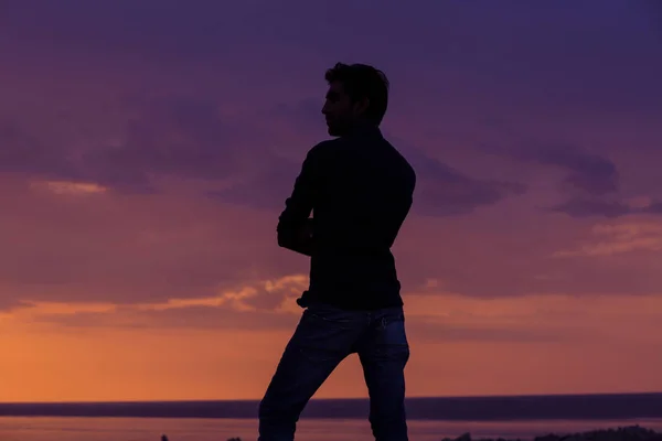 Hombre de negocios parado frente al mar al atardecer, perfil lateral del hombre parado pensando en el futuro — Foto de Stock
