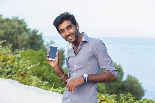 Primer plano feliz hombre indio sonriente mostrando el teléfono móvil. Concepto de personas y tecnología . — Foto de Stock