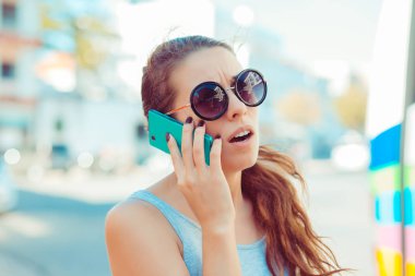 Dışında cep telefonu ayakta şehir arka plan ile konuşurken sinirli sinirli genç kadın portre. Olumsuz duygular duygular