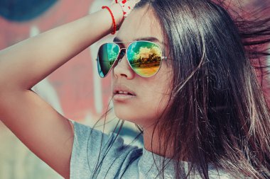 Güneş gözlüğü şehir görünümü yansıması. Portre portre emin başarılı güzel çekici esmer genç kadın moda kız model poz, koruyucu gözlük el baş izole açık kırmızı arka plan duvar üzerinde 