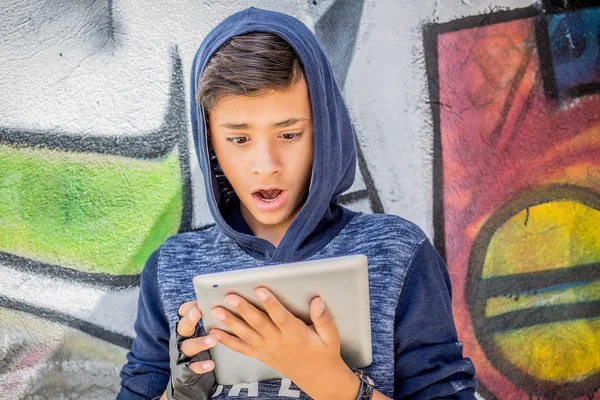 Closeup portrait child, shocked, surprised, funny looking boy using, holding pad tablet