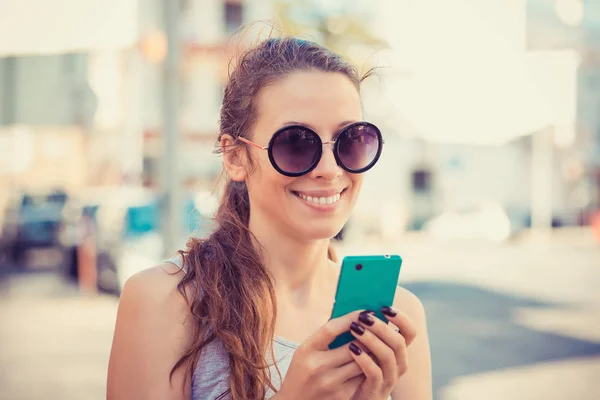 Young Woman in White Shirt Busy with her Mobile Phone While Walking a City Street — Stock Photo, Image