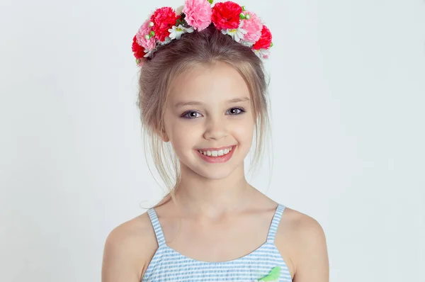 Close up retrato pouco alegre menina sorrindo na câmera na grinalda de flores — Fotografia de Stock