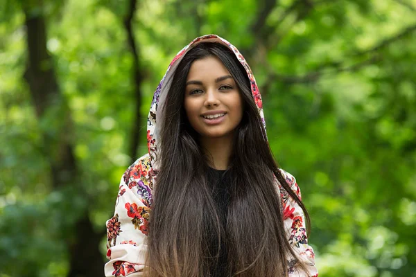 Молодий та щасливий. брюнетка молода жінка посміхається, дивлячись на вас ізольовані зелені дерева фон природи — стокове фото