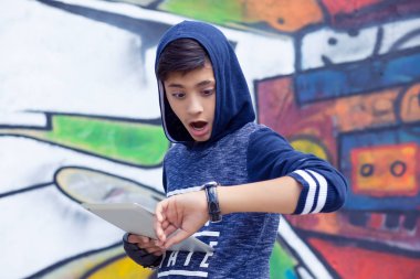 Çocuk, kol saati için grafiti duvarı arıyorum okula tablet pad geç ile adam