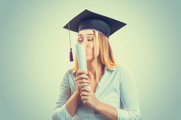 Happy graduate kissing her diploma