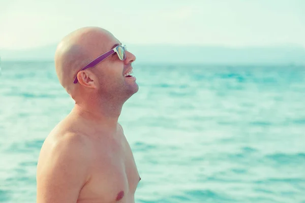 Uomo godendo la natura, sognando ad occhi aperti sorridendo guardando il mare isolato — Foto Stock