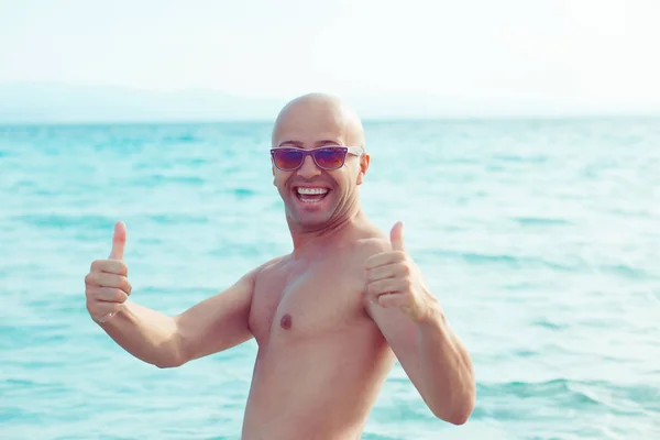 Hombre en el mar disfrutando de vacaciones pulgares hacia arriba gesto aislado paisaje marino —  Fotos de Stock