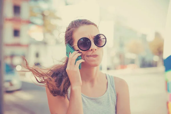 Скептична жінка розмовляє по телефону вирішуючи, що відповісти — стокове фото