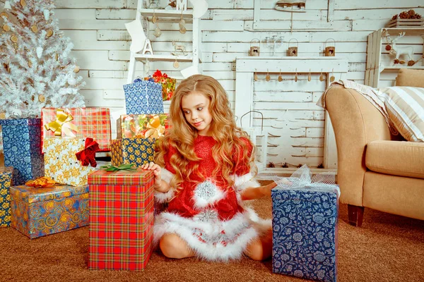 Legrační dívka, která nosí vánoční Santa kostým 2 dárkové krabičky nevěděl, který otevřít — Stock fotografie